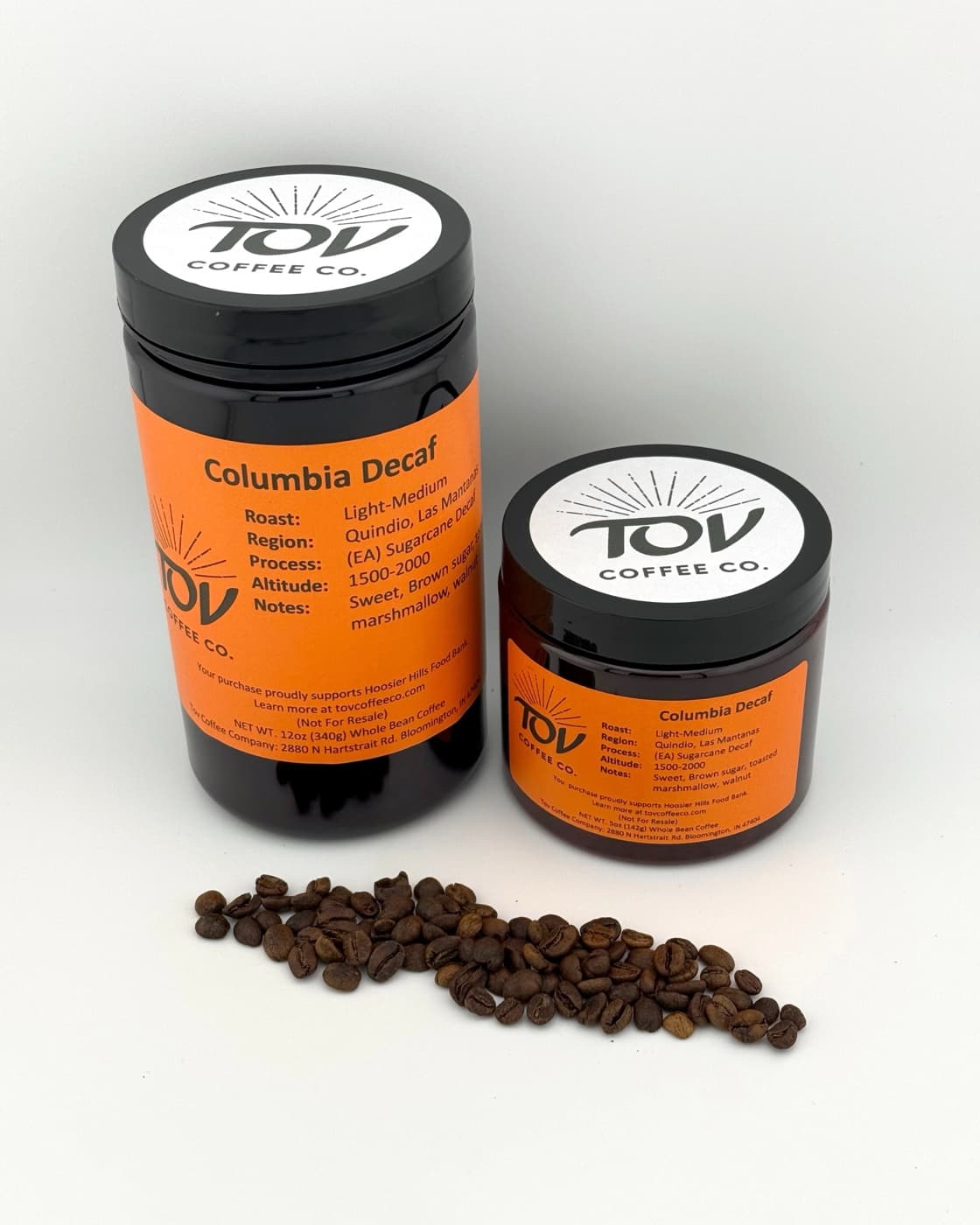 A 12oz jar of Tov Colombia Decaf, with roasted beans beside it.